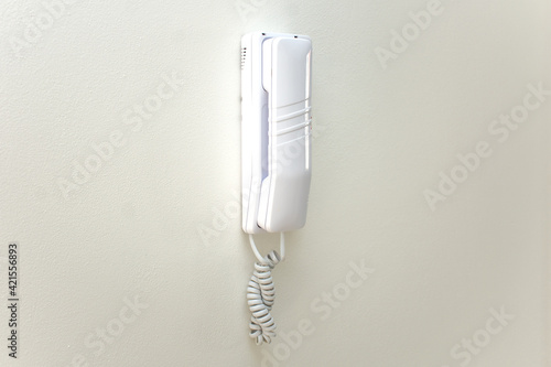 Intercom on white wall at home. Phone comunication in house concept with copy space.