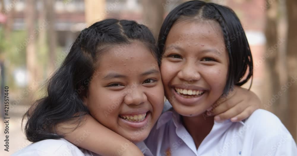 Slow motion scene of two young native Asian female student girls in white uniform who had pimple on their foreheads are laughing happily and joyful together on the natural bokeh background. Slow motion scene of two young native Asian female student girls in white uniform who had pimple on their foreheads are laughing happily and joyful together on the natural bokeh background.
