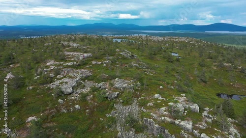 Aerial view of a hikers on sitting in rocky Lapland taiga and tundra - descending, drone shot photo