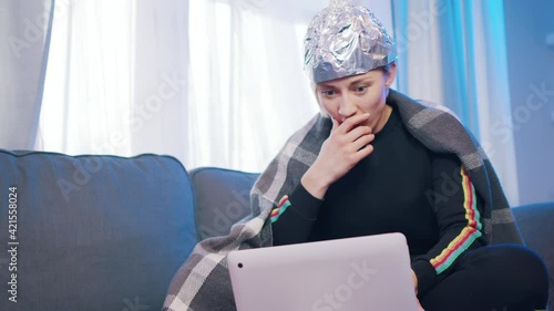 Conspiracy theories enthusiast watching paradocumentary in quarantine alone photo