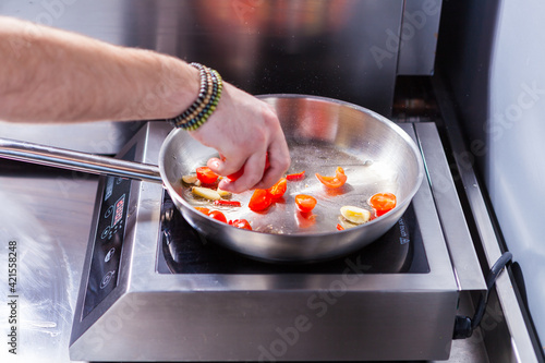 Roasted cherry tomatoes cooking food for italian cuisine, tomato sauce for pasta, mediterranean diet concpet, detailed view of pan with fried tomatoes