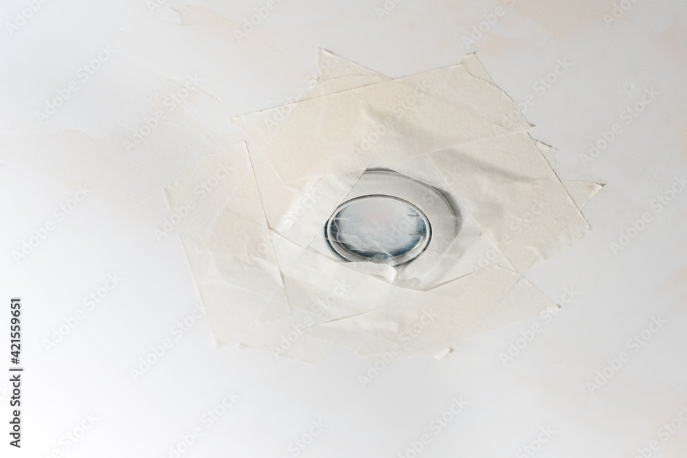 The ceiling lamp is sealed with masking tape during the repair. Protection of the light bulb during repair from fine dust The ceiling lamp is sealed with masking tape during the repair. Protection of the light bulb during repair from fine dust