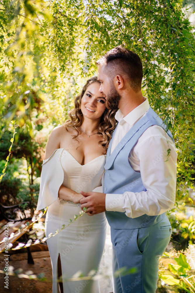 groom in blue suit and bride with curls of stand in willow groom in blue suit and bride with curls of stand in willow
