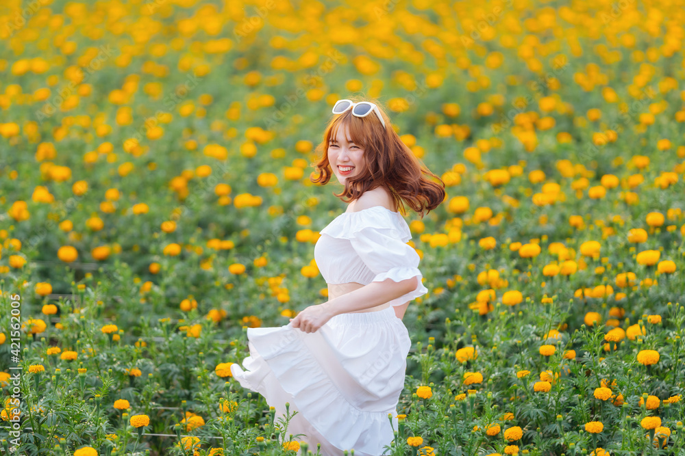 Beautiful Asian woman wear white dress walking in marigold flowers garden. Beautiful Asian woman wear white dress walking in marigold flowers garden.