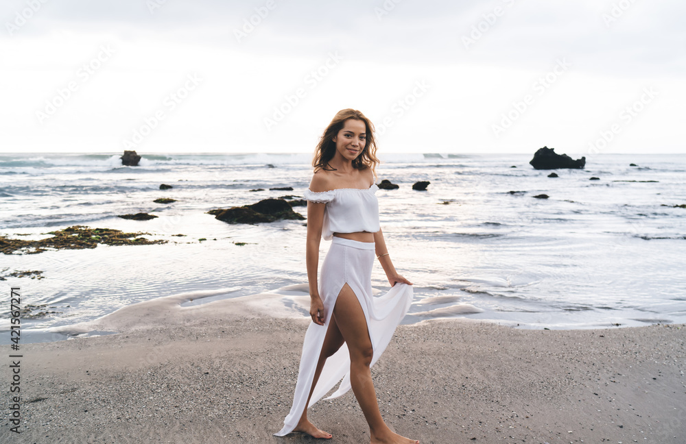 Content woman walking along seashore Content woman walking along seashore
