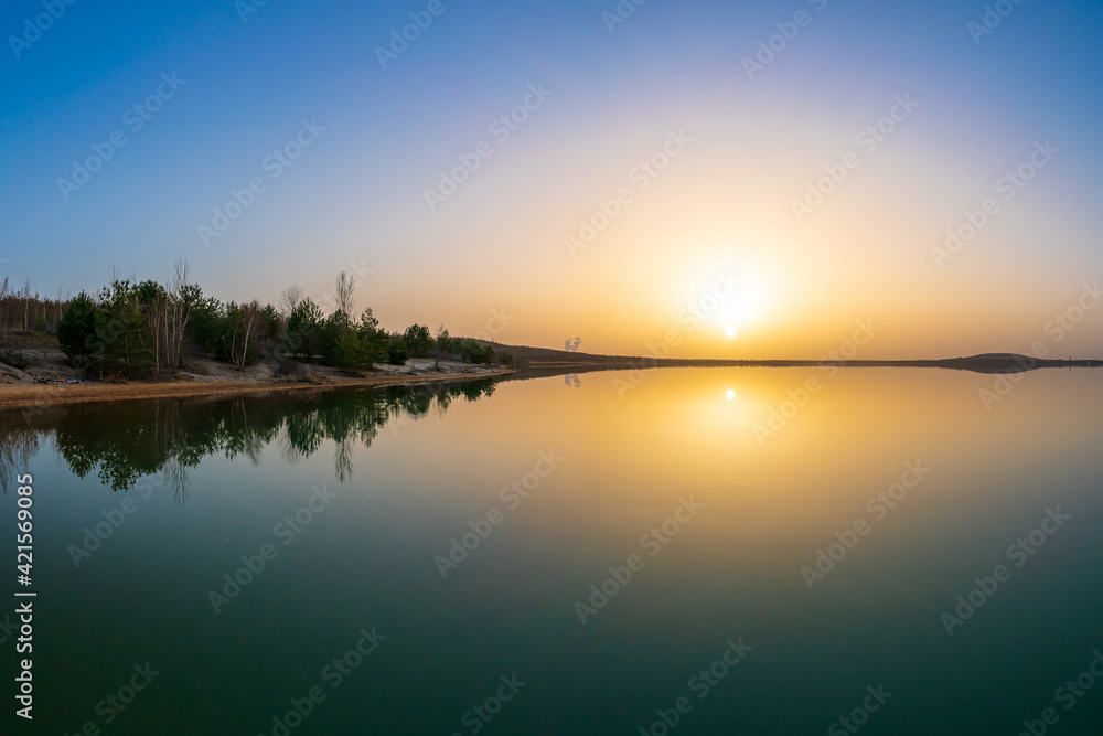 Beautiful sunset at a lake with a calm water surface