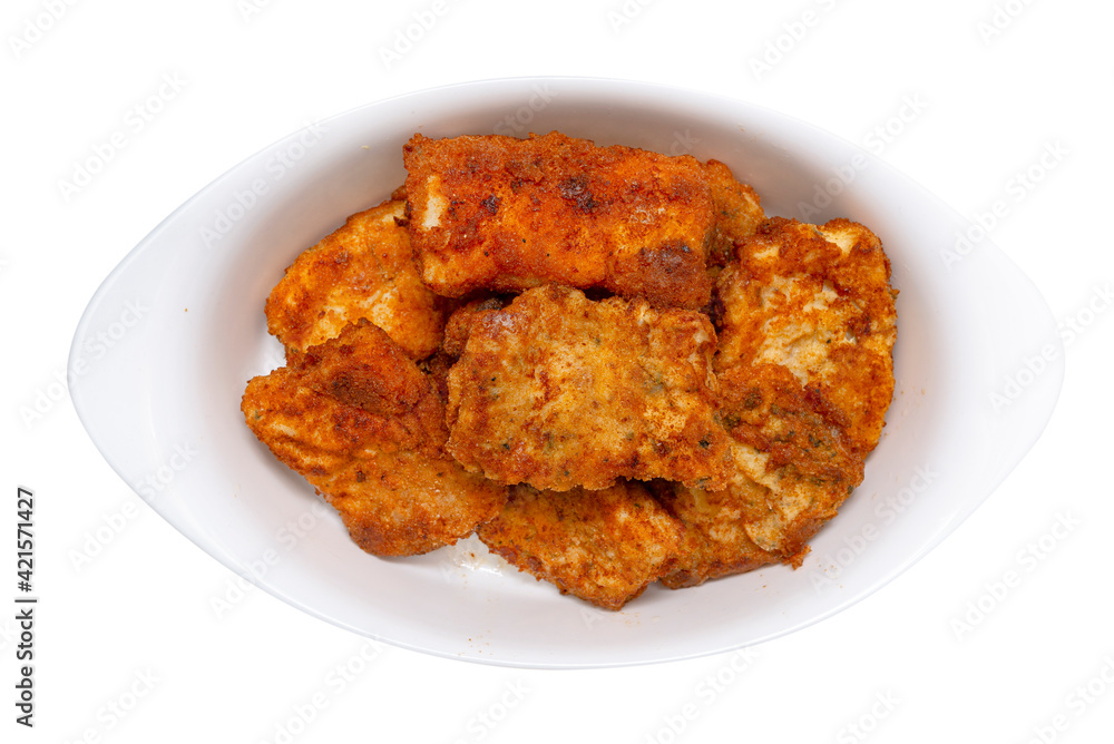 Fried cod fillets cut into squares lying on a white plate, isolated on a white background with a clipping path, top view. Fried cod fillets cut into squares lying on a white plate, isolated on a white background with a clipping path, top view.