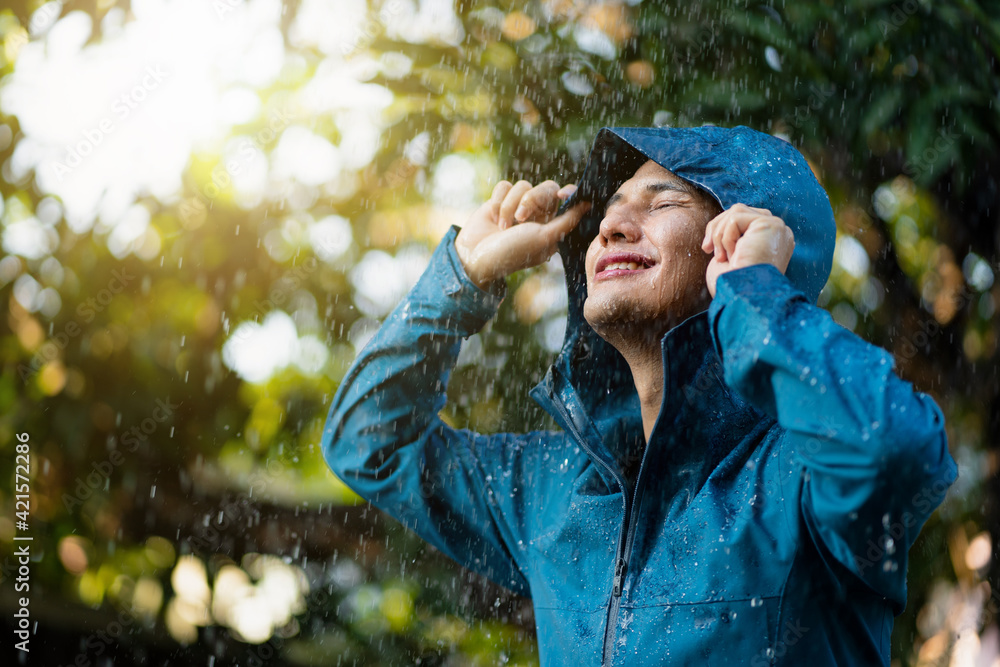 Poster Affiche Young Asian man wearing raincoats in the outdoor. 40x26.7 cm