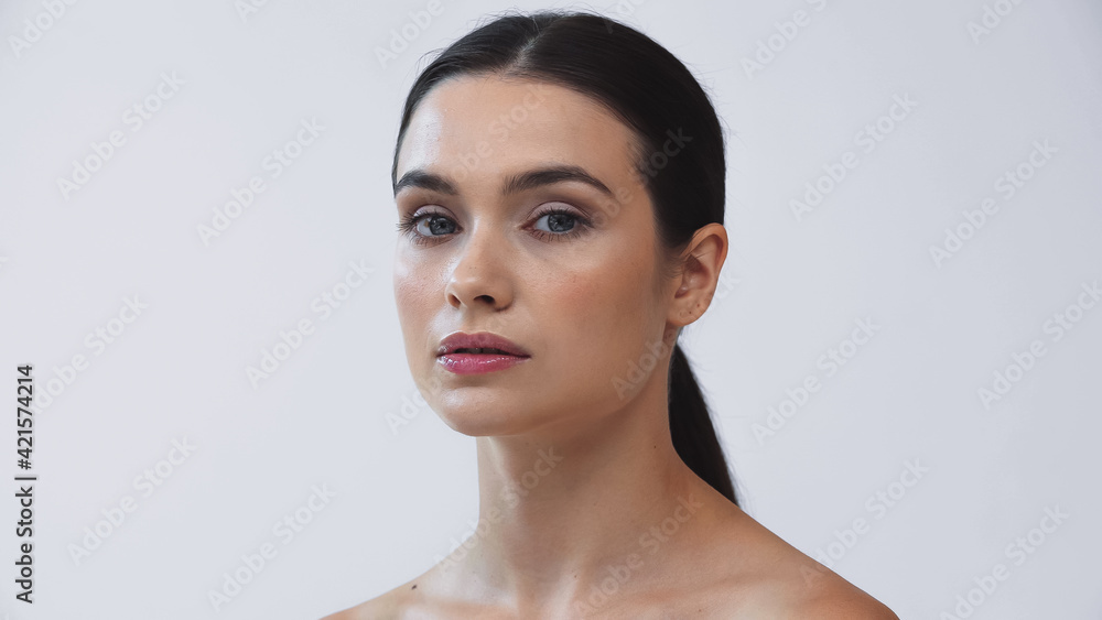 young, brunette woman with perfect face looking at camera isolated on grey young, brunette woman with perfect face looking at camera isolated on grey