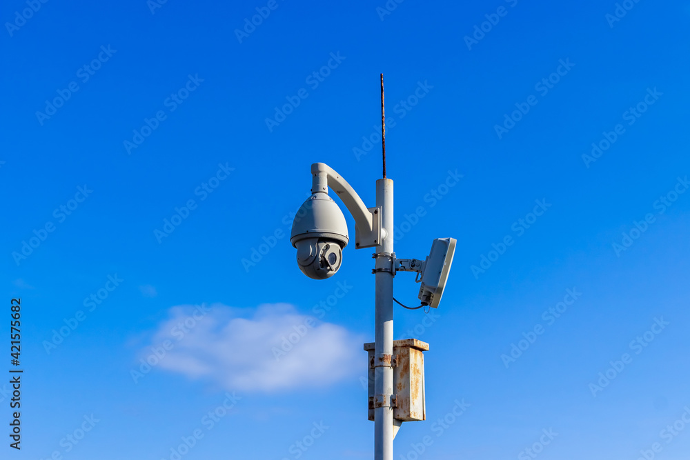Outdoor Wireless Controlled Security Surveillance Camera on pole against blue sky background