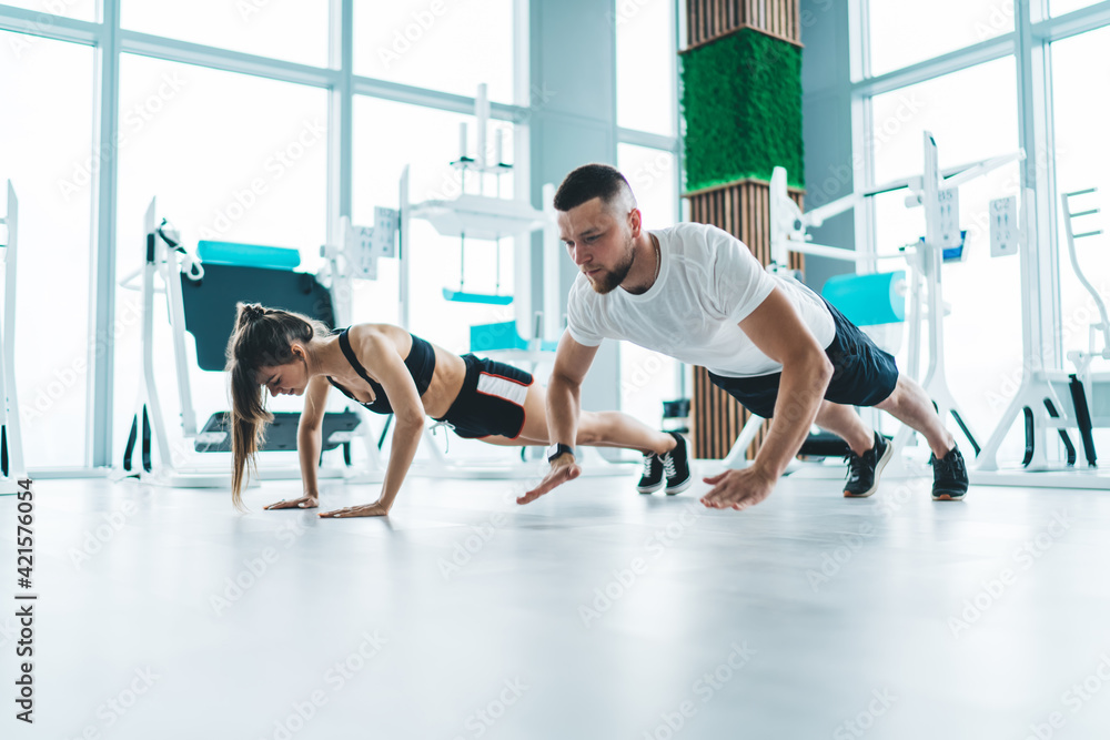 Fototapeta premium Young sporty couple doing push ups