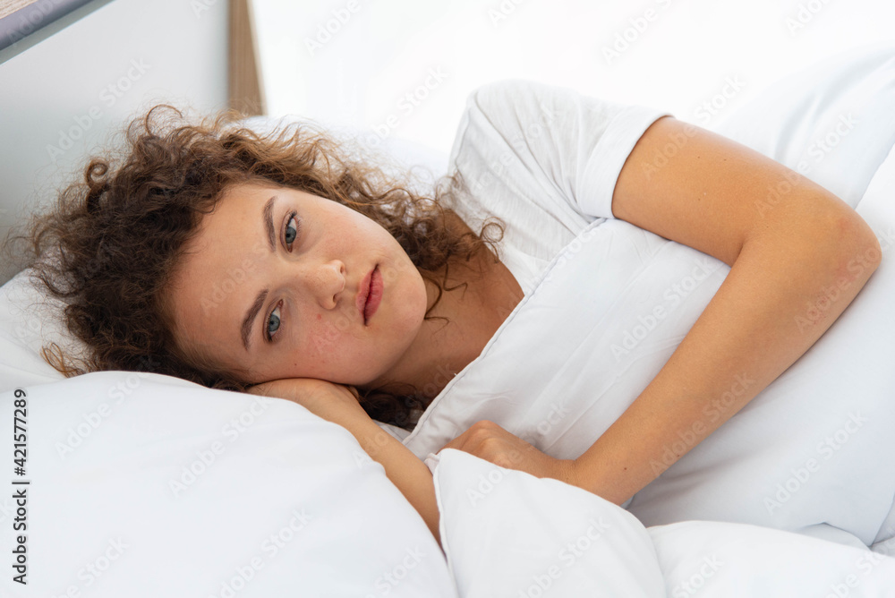 Young depressed woman have family problem lying on white bed Young depressed woman have family problem lying on white bed