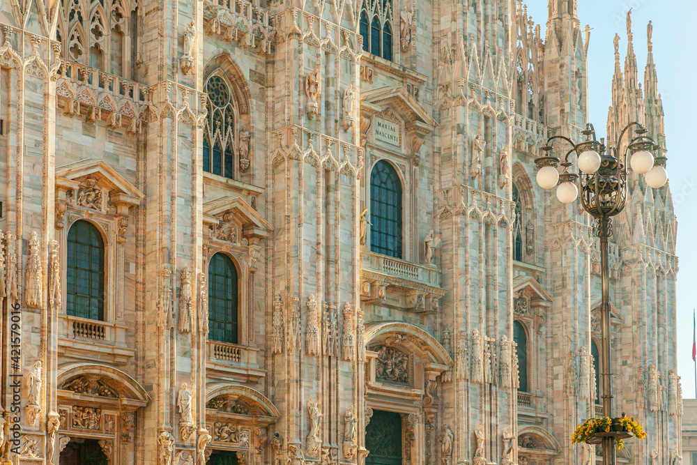 Famous church Milan Cathedral Duomo di Milano with Gothic spires and white marble statues. Top tourist attraction on piazza in Milan Lombardia Italy. Wide angle view of old Gothic architecture and art