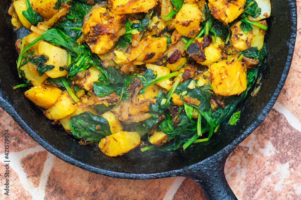 Saag Aloo, Indian style spinach and potatoes in cast iron pan Saag Aloo, Indian style spinach and potatoes in cast iron pan
