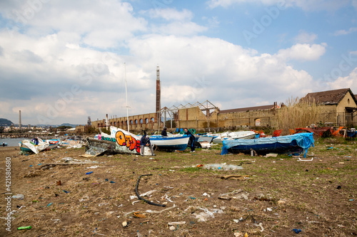 MARCH 6, 2021 - NAPOLI, ITALY - Bagnoli, Coroglio beach, in the west part of Napoli, ex area of ​​the Italsider factories. In the background the remains of the "City of Science" burned in 2013