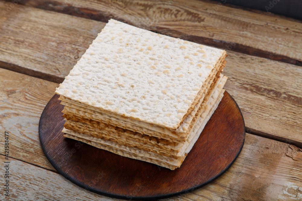 Matzo stack on a round stand on a wooden table.