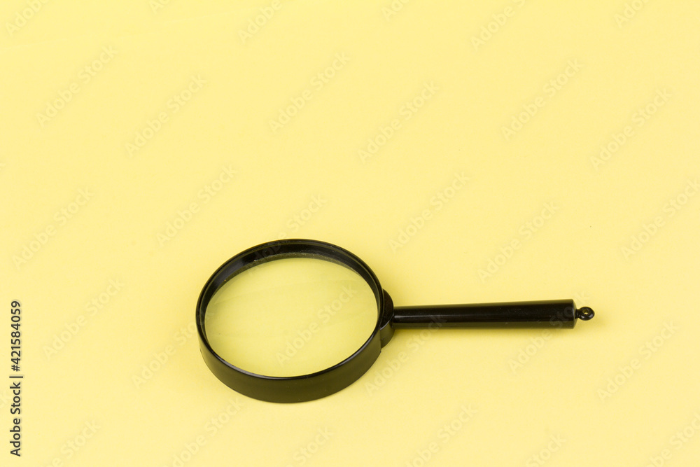 Close up of a magnifying glass on a yellow background. Science research concept. Copy space. Creative minimalism. Design element. Close up of a magnifying glass on a yellow background. Science research concept. Copy space. Creative minimalism. Design element.