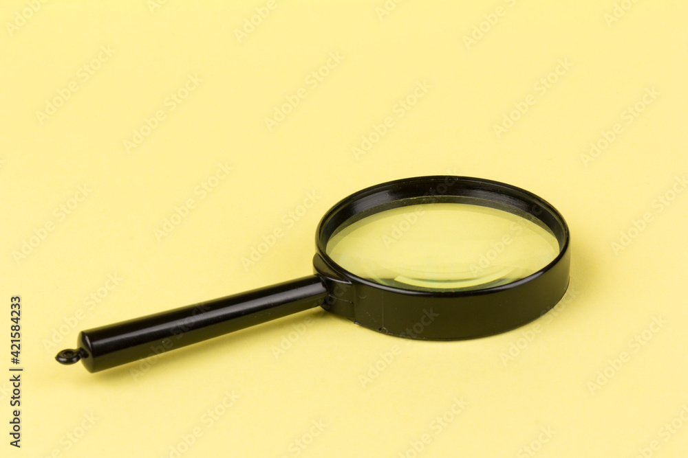 Close up of a magnifying glass on a yellow background. Science research concept. Copy space. Creative minimalism. Design element. Close up of a magnifying glass on a yellow background. Science research concept. Copy space. Creative minimalism. Design element.