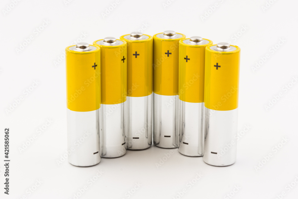 Photo of gray-yellow alkaline AA batteries on white background. Recycling of rechargeable NiMH batteries. The most popular size of accumulators. Copy space. Photo of gray-yellow alkaline AA batteries on white background. Recycling of rechargeable NiMH batteries. The most popular size of accumulators. Copy space.