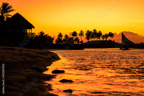 Silhueta de jangada num rio durante pôr do sol. photo