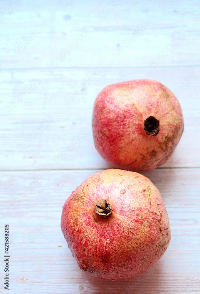 two handsome pomegranates, red fruit, pomegranates on a light wooden background, pomegranates two handsome pomegranates, red fruit, pomegranates on a light wooden background, pomegranates