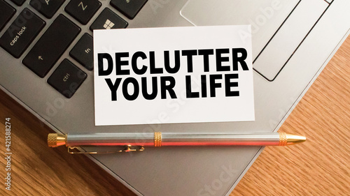 Notepad with inscriptions DECLUTTER YOUR LIFE on a white background. business concept.
