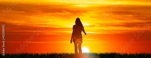 Silhouette einer Frau mit langen Haaren vor Sonnenuntergang