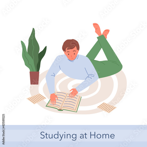 Home education, young student man studying, lying on floor carpet, reading paper books