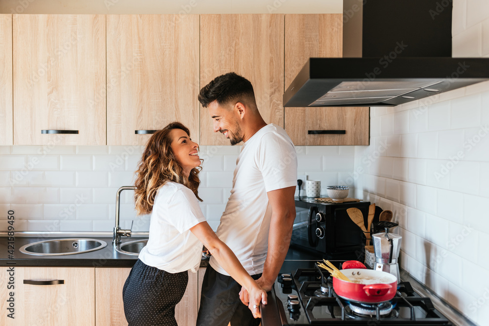 young bride and groom, smiling and happy in the kitchen young bride and groom, smiling and happy in the kitchen