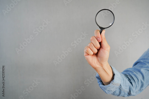close up man hand hold magnify glass for searching information or business marketing concept