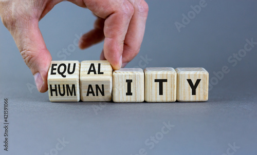 Equality and humanity symbol. Businessman turns wooden cubes and changes the word 'equality' to 'diversity'. Beautiful grey background. Business, equality and humanity concept. Copy space.