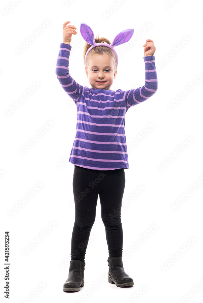Cute happy girl with bunny ears hat celebrating Easter with raised hands looking at camera. Full body isolated on white background Cute happy girl with bunny ears hat celebrating Easter with raised hands looking at camera. Full body isolated on white background