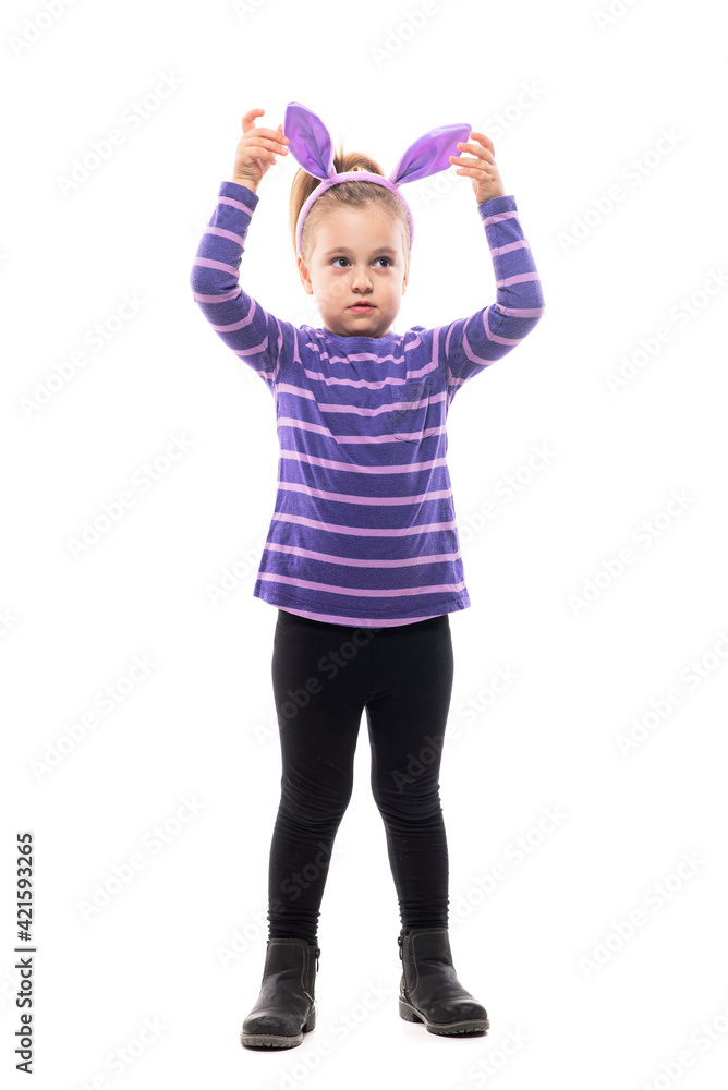 Adorable girl child looking away touching Easter bunny hat ears with uncertainty. Full body isolated on white background Adorable girl child looking away touching Easter bunny hat ears with uncertainty. Full body isolated on white background