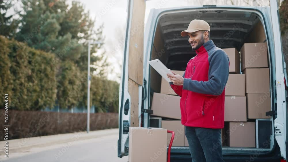 Young man using tablet to view information about the parcel. Delivering the package. High quality 4k footage Young man using tablet to view information about the parcel. Delivering the package. High quality 4k footage