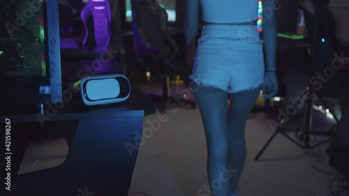 Girl gamer walks to the computer in the gaming club  photo