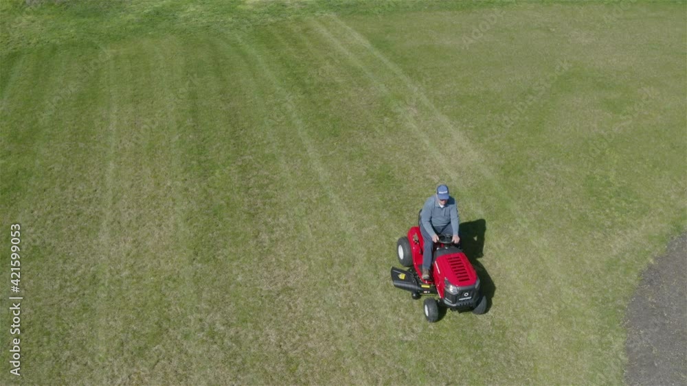 Man Mowing the Lawn on His Riding Mower Man Mowing the Lawn on His Riding Mower