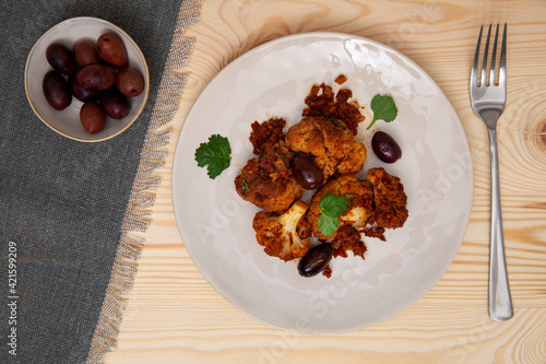 Cauliflower with tomato sauce cooked salad with olives. Moroccan cuisine. photo