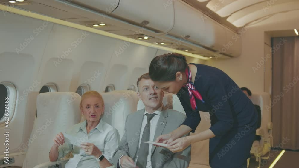 A beautiful woman cabin crew is smile greeting to passengers onboard , lifestyle and business travel concept A beautiful woman cabin crew is smile greeting to passengers onboard , lifestyle and business travel concept