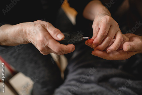 Close up off woman checking blood sugar her diabetic husband 