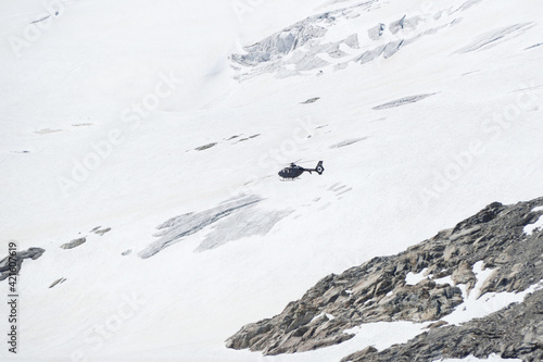 Swiss Airforce EC 635 Helicopter flying over a glacier photo