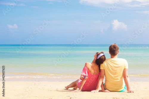 happy young couple lying and having fun on a tropical beach