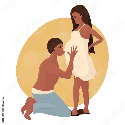 Young black couple in love waiting for the birth of a baby. The man is on his knees and kisses his pregnant wife on the stomach. Happy pregnancy and motherhood. Maternity leave for future parents.