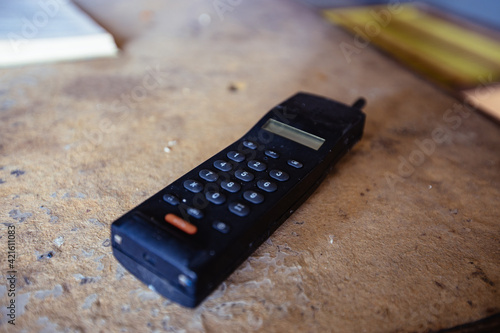 Old retro mobile telephone on wooden table, selective focus photo