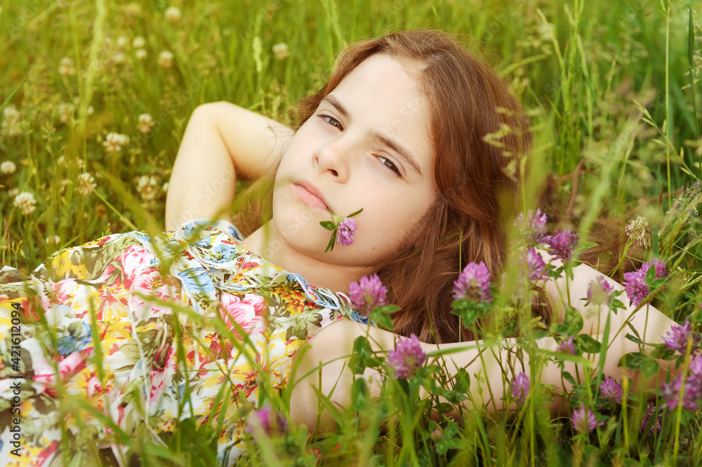girl of 10 years old lies on the grass among the flowers girl of 10 years old lies on the grass among the flowers