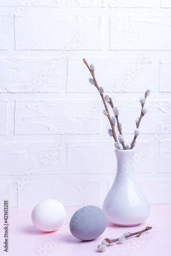 Spring and Easter holiday concept. Pussy willow branches in white vase and eggs.