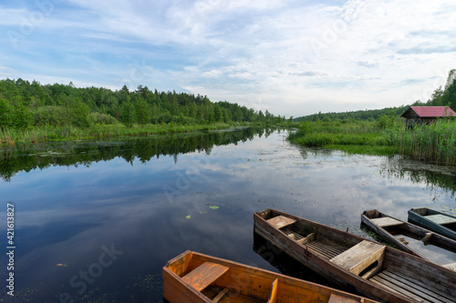 Fototapeta Naklejka Na Ścianę i Meble -  Old wooden boats near the river pier on a warm summer day.