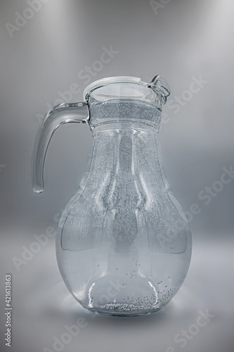 transparent glass jug on gray background