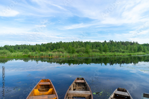 Old wooden boats near the river pier on a warm summer day.