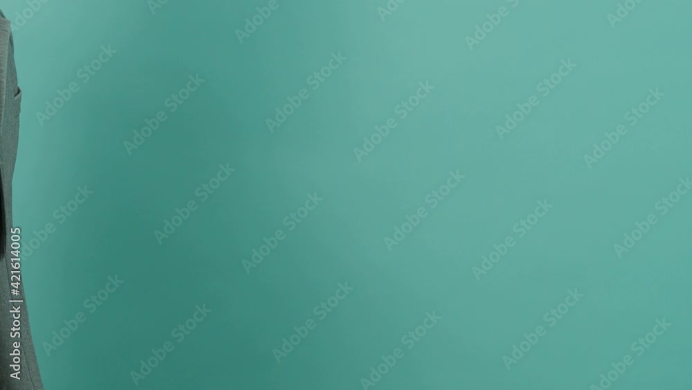 Movie clapperboard clapped. Close up hand hold empty black and yellow stripe film making movie slate isolated on blue green background studio. Open and close film slate for video production. Movie clapperboard clapped. Close up hand hold empty black and yellow stripe film making movie slate isolated on blue green background studio. Open and close film slate for video production.