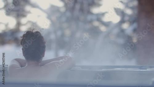 Nordic spa in a winter paradise. Escape the city and the bustle of every day. Hot spring overlooking the fresh snowfall in a winter retreat. Shot in 4k. 